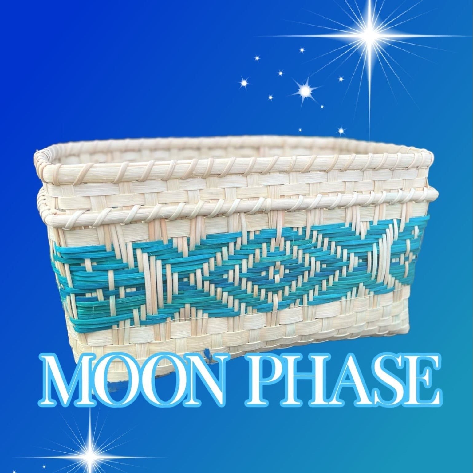 A rectangular woven basket with a natural straw base and turquoise geometric designs. The basket features intricate patterns and is set against a starry blue background. Text overlay reads "MOON PHASE."